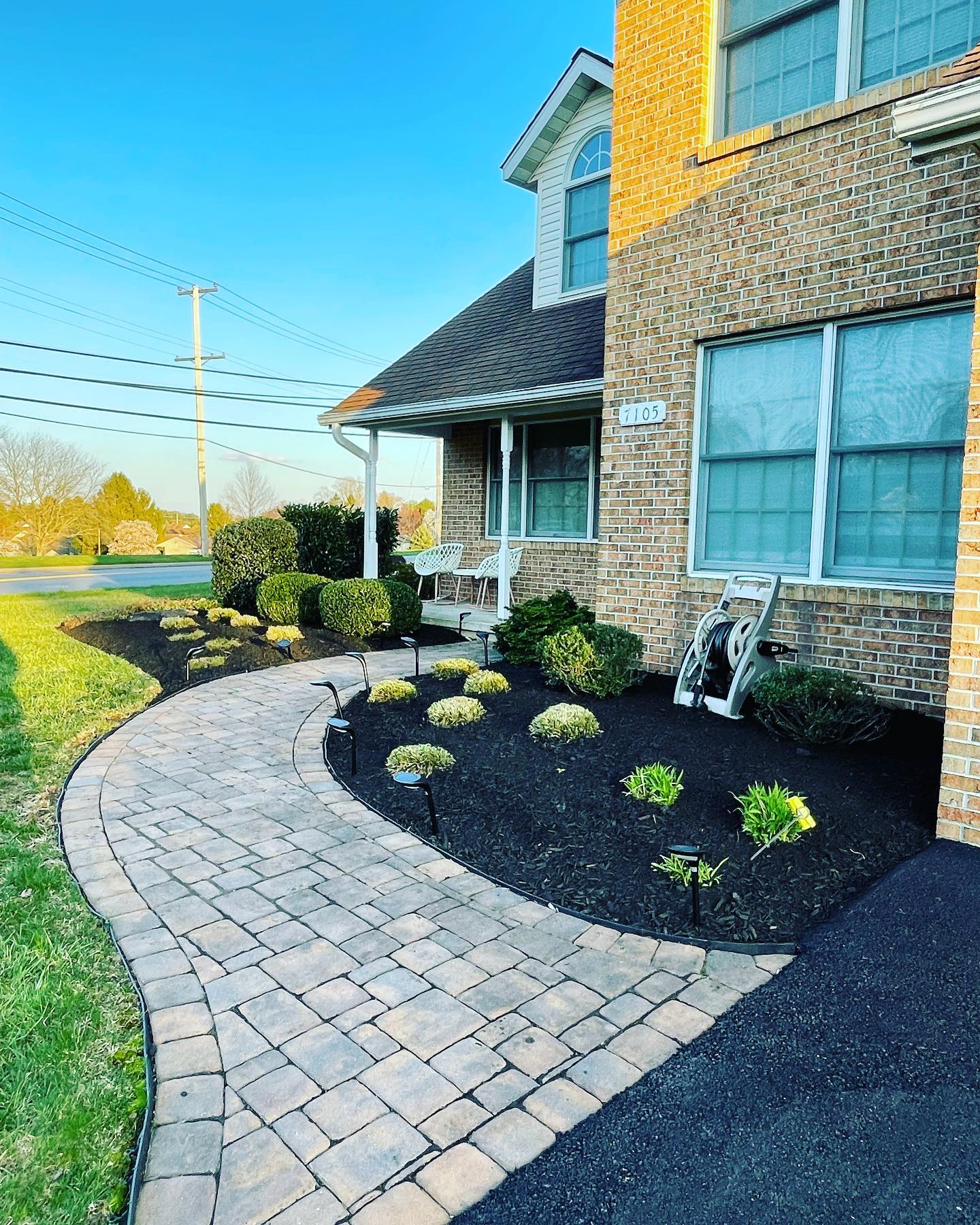 Paver walkway with fresh mulch beds and solar path lights